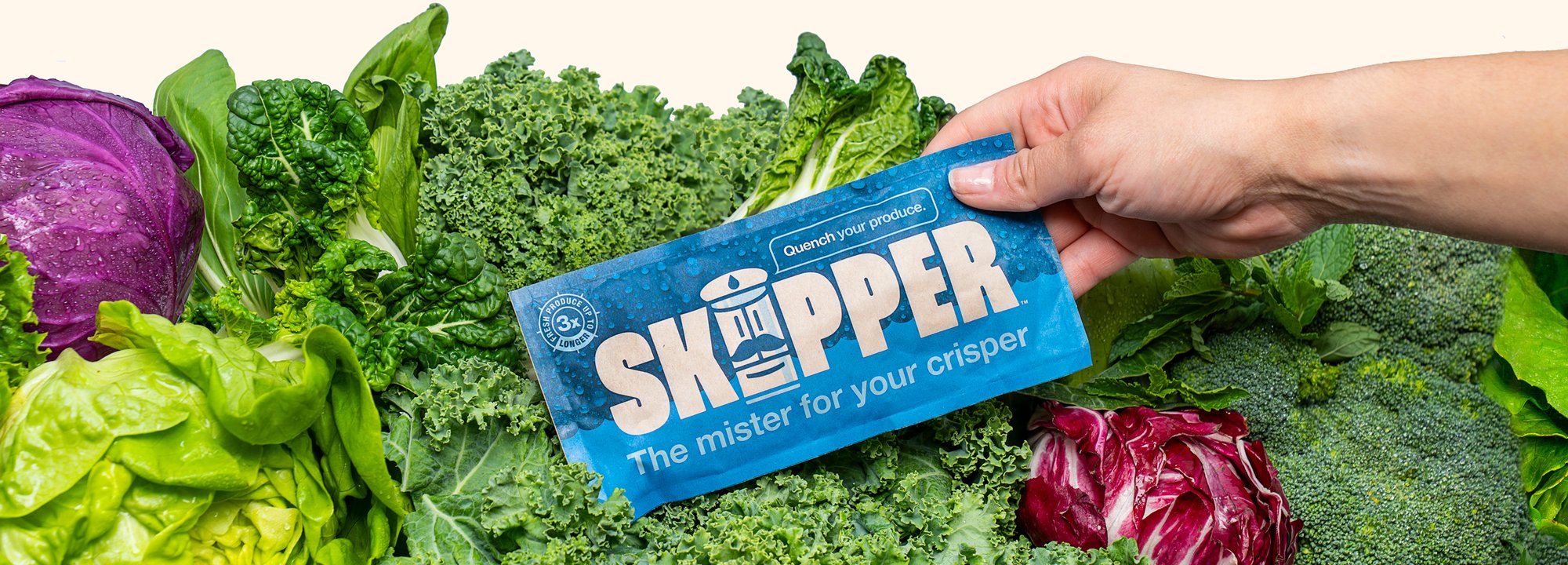 A hand placing a Skipper in to a bed of fresh vegetables